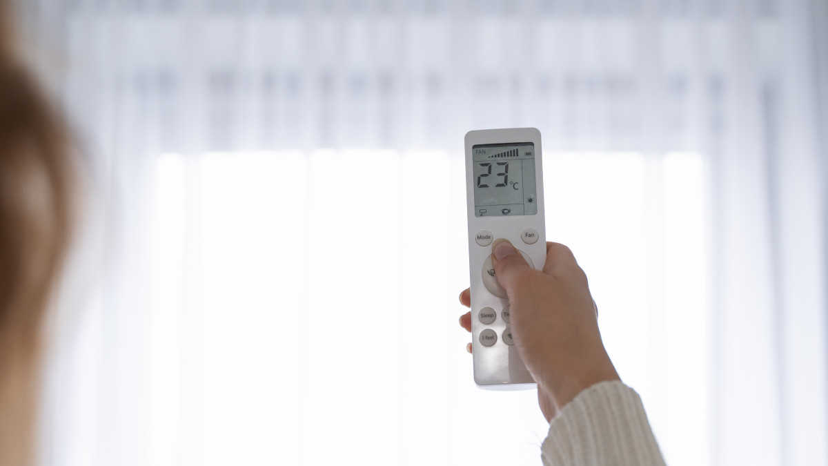 Femme tenant dans sa main une telecommande