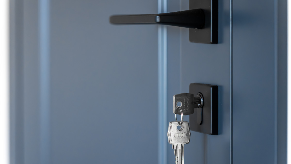 gros plan sur une serrure avec une clé sur une porte grise